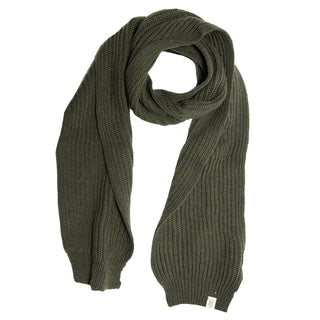 A thick, dark green Hand Loom Laurent Scarf, handmade in Nepal from merino wool, is laid flat on a white background with one end looped over the other and a small white tag near one corner.