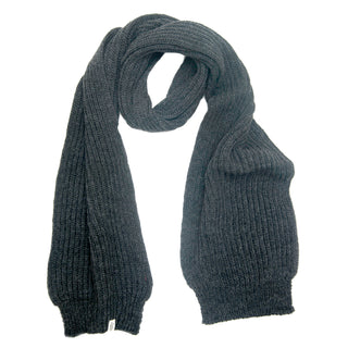 A long, dark gray Hand Loom Laurent Scarf, handmade in Nepal from merino wool with a ribbed texture, is laid flat on a white background with both ends visible.