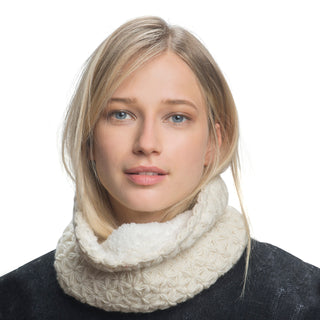 A woman with blonde hair, wearing a white I See Stars Neckwarmer handmade in Nepal and a dark top, gazes directly at the camera against a white background.