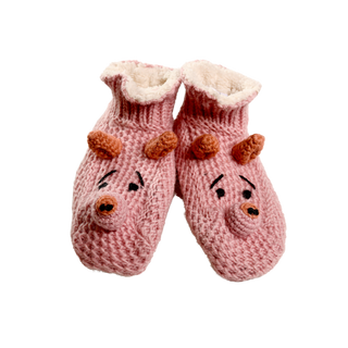 A pair of Piggy Slippers is pictured. The pink hand-knit wool slippers feature an animal face design with brown antlers, embroidered eyes, and a nose. The interior is lined with a soft, fluffy material, making them the perfect winter accessory.