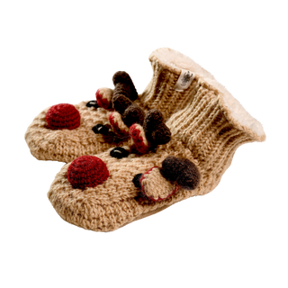 Introducing the Reindeer Slippers— a charming pair of beige, hand-knit wool baby booties with a cozy interior. These delightful slippers feature decorative, colorful knit elements including red, brown, and black accents, which give them a playful reindeer appearance. They are perfect for keeping your little one's feet warm and snug during the winter months.