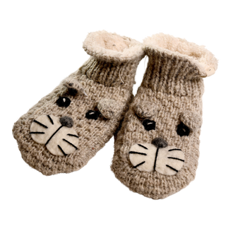 A pair of Shmil The Cat Slippers, hand-knit in Nepal from soft merino wool, designed to resemble animal faces with embroidered eyes, noses, and whiskers on the front. These cozy slippers have a textured appearance and are perfect for infants or toddlers.