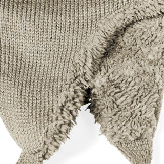 Close-up of the Hand Knit Snug Hat in beige, featuring textured knit yarn on the left and soft fleece fabric on the right, displayed against a white background.