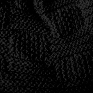 Close-up view of the Hand Knit Sena Hat reveals its dark, textured knitted fabric with a subtle zigzag pattern, reminiscent of artisanal craftsmanship. The thick yarn forms tightly woven stitches, resulting in a soft, tactile surface. Low lighting enhances the shadows and highlights the rich texture of the hat.