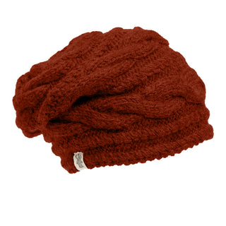 The Triple Braid Cable Slouch is a deep red, textured slouchy beanie hand-knit in Nepal from soft Merino Wool, featuring a small white logo tag on the rim and shown on a plain white background.