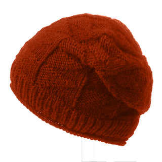 The Wave Slouch is a red knitted beanie with a textured pattern, shown from the side against a white background—a stylish and warm winter hat.