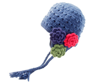 A handmade in Nepal, Crochet 3 Flower Earflap beanie in blue wool with decorative flowers in purple, red, and green, featuring braided ties with tassels at the ends.