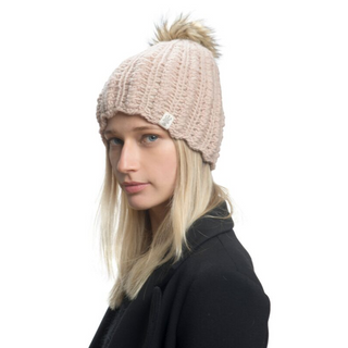 A woman wearing a Layla Beanie with a scallop knit pattern and a pompom on top against a white background.