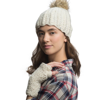 A young woman wearing a white Layla Beanie with a pom-pom, handmade in Nepal, and a plaid shirt.