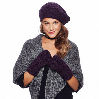 A woman wearing a purple Say It With a Rose Beret hat and matching fingerless gloves paired with a gray knitted shawl over a black top, smiling at the camera.