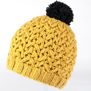A handmade yellow knitted Black Pom Beanie, crafted from merino wool.