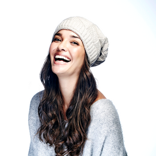A smiling woman wearing a Wave Slouch beanie.