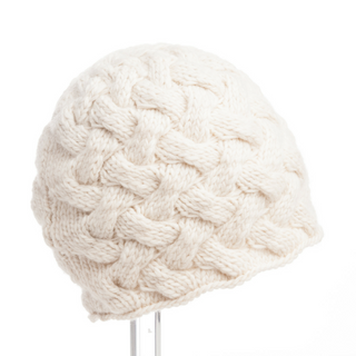 A white, handmade in Nepal,  Holden Beanie displayed on a stand against a white background.