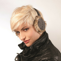 A person with short blonde hair is wearing Hand Knit Cable Adjustable Earmuffs With Faux Fur and a black leather jacket, looking at the camera with a slight smile against a plain white background.