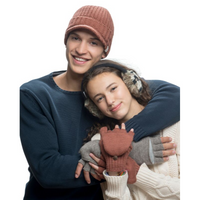 Two people in winter clothing pose together. The person on the left wears a knit hat and navy sweater, smiling with an arm around the other. The person on the right wears Hand Crochet Kaleidoscope Earmuffs with an adjustable band, along with gloves and a cream sweater, leaning in and smiling slightly.