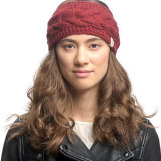 A woman with long wavy hair wearing a red cable knit Full Soho Headband with fleece lining and a black leather jacket.
