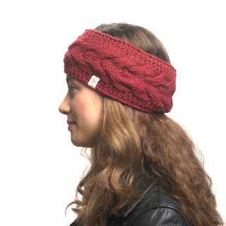 A woman in profile wearing a red cable knit Full Soho Headband with a tag visible on the side.