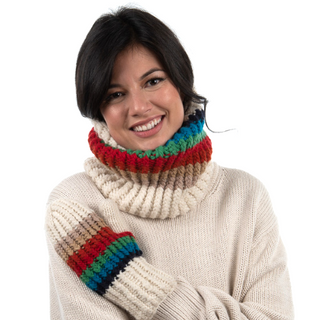 A woman with short black hair wearing a cream-colored sweater and a colorful, handmade in Nepal Hi Fidelity Neckwarmer smiles at the camera.