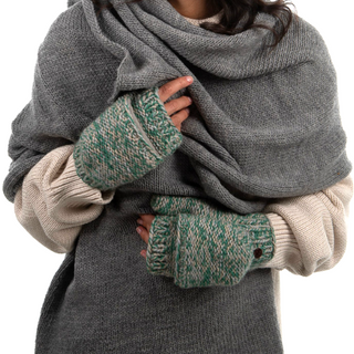 A person wearing a gray sweater and scarf with green and white Bedford Fingerless Gloves with flap, handmade in Nepal. Only the torso and folded hands are visible in the image.