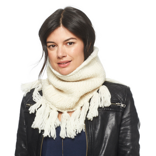 A woman wearing a black leather jacket and a Sweet Emotions Neckwarmer, handmade in Nepal with thick white merino wool.