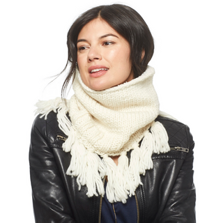 Sentence with product name: Woman wearing a white Sweet Emotions Neckwarmer with sherpa fleece lining and a black leather jacket, looking to the side with a subtle smile.