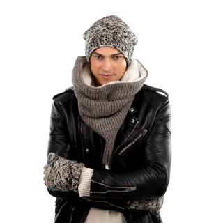 A man dressed in winter clothing, including a merino wool beanie and a thick Mick Neckwarmer, wearing a leather jacket and looking at the camera with his arms crossed.