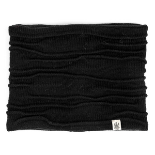 A plain black, wool ribbed Branch Out Neckwarmer with a small white label on the lower right side, handmade in Nepal.