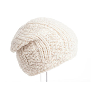A white wool Caliber Slouch beanie displayed on a stand against a white background.