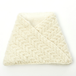A folded Dream On Neckwarmer with a cable pattern displayed on a white background.