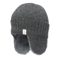 The Hand Loom Rib Band Earflap Hat is a gray knit winter hat with ribbed fold-over brim and ear flaps lined with soft, fuzzy material, featuring a small rectangular white patch with an emblem sewn on the front.