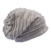 The Hand Loom Branch Out Slouch is a light gray, slouchy knit wool beanie featuring a ribbed texture and a small fabric tag on the brim, displayed against a plain white background.