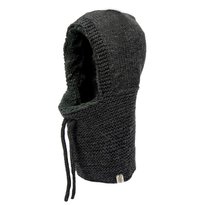 The Hand Knit Eddy Hood is a black balaclava featuring a textured knit pattern, an open face area, and two drawstrings at the front. Handmade in Nepal, this piece is photographed against a plain white background.