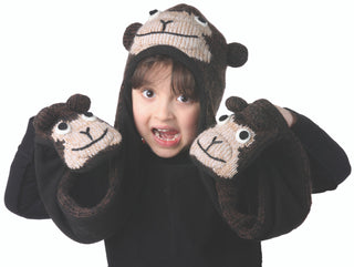 A child wearing a black shirt, a Cheeta Monkey Hatscarf, and matching mittens, smiling and looking at the camera with an excited expression.