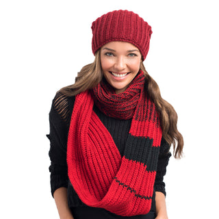 A smiling woman wearing a red knitted hat and Ivy League Infinity Scarf, handmade in Nepal, set against a white background.
