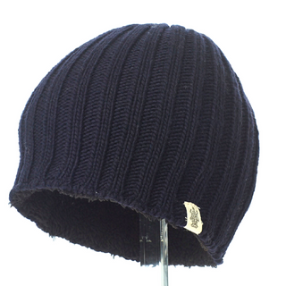 A handmade in Nepal Chase Beanie displayed on a clear stand.