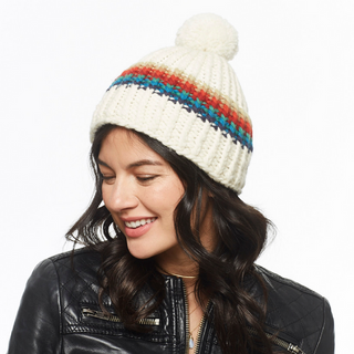 A woman smiling gently, wearing a Hi Fidelity Beanie w/ Pom, paired with a black leather jacket.