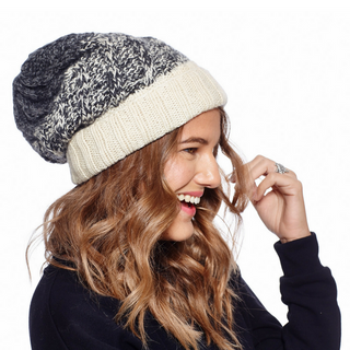 A woman wearing a Two Tone Cable Rib Fold Slouch knit beanie.