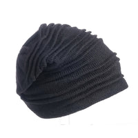 The Hand Loom Branch Out Slouch, a black knitted wool beanie featuring a slouchy, ruched design, is shown against a plain white background.